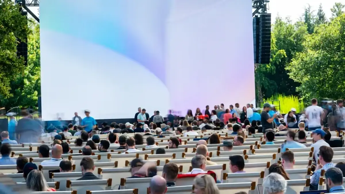 Vue du public rassemblé devant l’écran principal de la WWDC 2025 en plein air