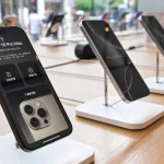 iPhone 16 Pro Max exposé en boutique, écran allumé affichant prix et détails techniques