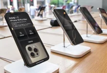 iPhone 16 Pro Max exposé en boutique, écran allumé affichant prix et détails techniques