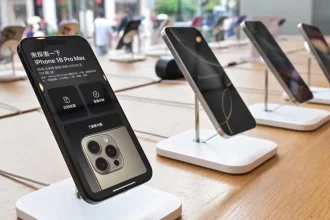 iPhone 16 Pro Max exposé en boutique, écran allumé affichant prix et détails techniques