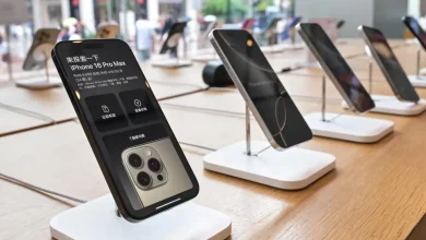 iPhone 16 Pro Max exposé en boutique, écran allumé affichant prix et détails techniques