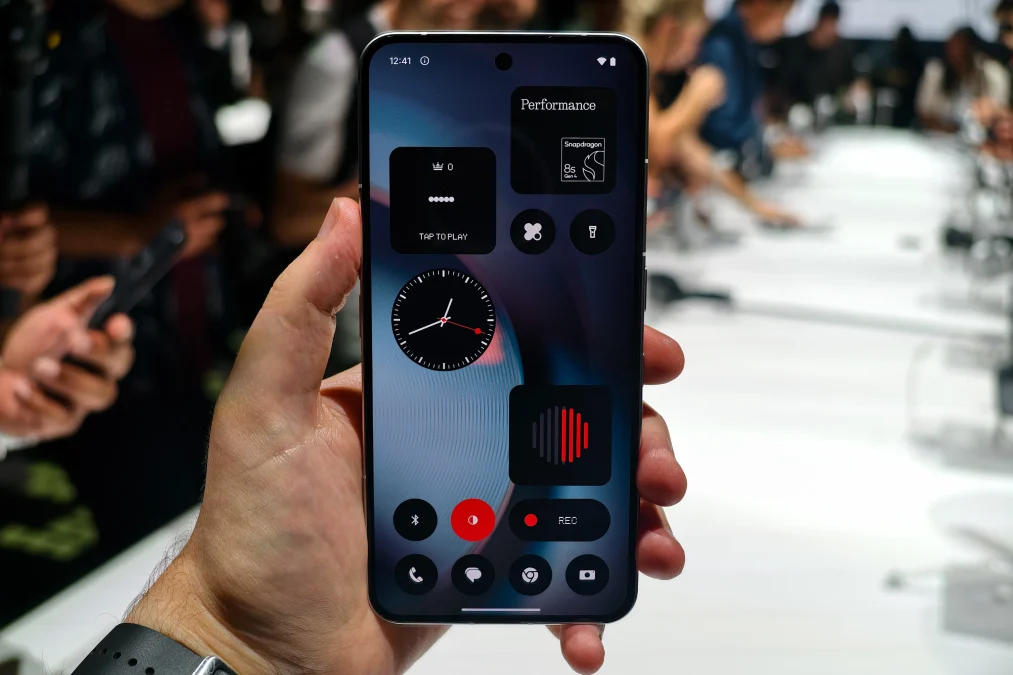Main tenant le Nothing Phone 3 affichant l’écran d’accueil avec widgets et interface.