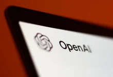 Logo d’OpenAI affiché sur l’écran d’une tablette, sur fond rouge