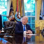 Le président signe une proclamation H-1B dans le Bureau ovale aux côtés d’un conseiller.