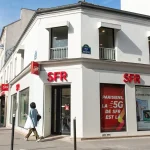 Façade d’une boutique SFR à Paris illustrant l’actualité du rachat envisagé par Orange Bouygues et Free