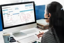 Femme travaillant sur un ordinateur affichant une facture payée, illustrant un logiciel de facturation pour TPE.