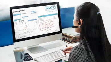 Femme travaillant sur un ordinateur affichant une facture payée, illustrant un logiciel de facturation pour TPE.
