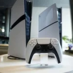 Deux consoles PlayStation 5 et une manette DualSense posées sur un socle blanc.