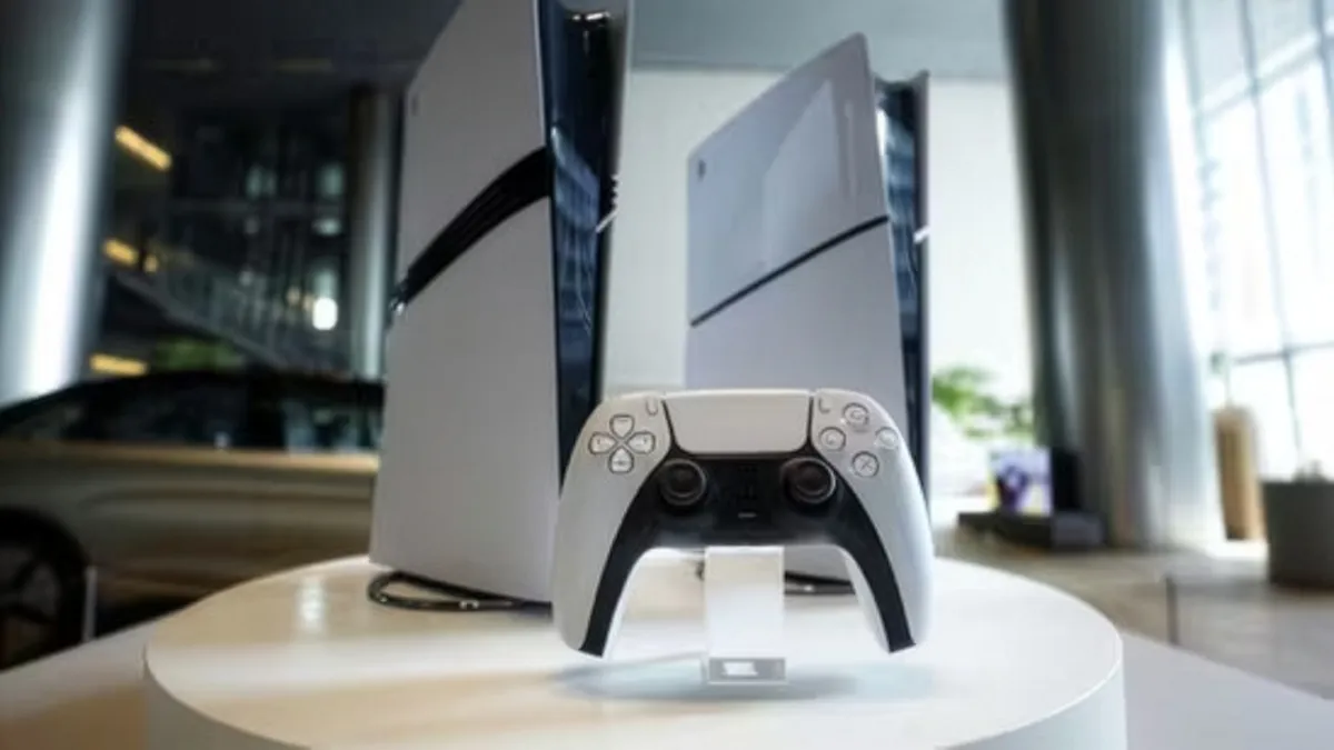 Deux consoles PlayStation 5 et une manette DualSense posées sur un socle blanc.