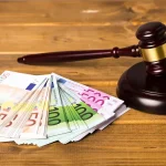 Maillet de juge posé à côté de billets en euros, illustrant la régulation du découvert bancaire.