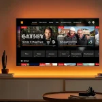 TV d’Orange sur téléviseur Philips Titan OS, écran d’accueil en direct et replay, halo Ambilight éclairant le mur du salon