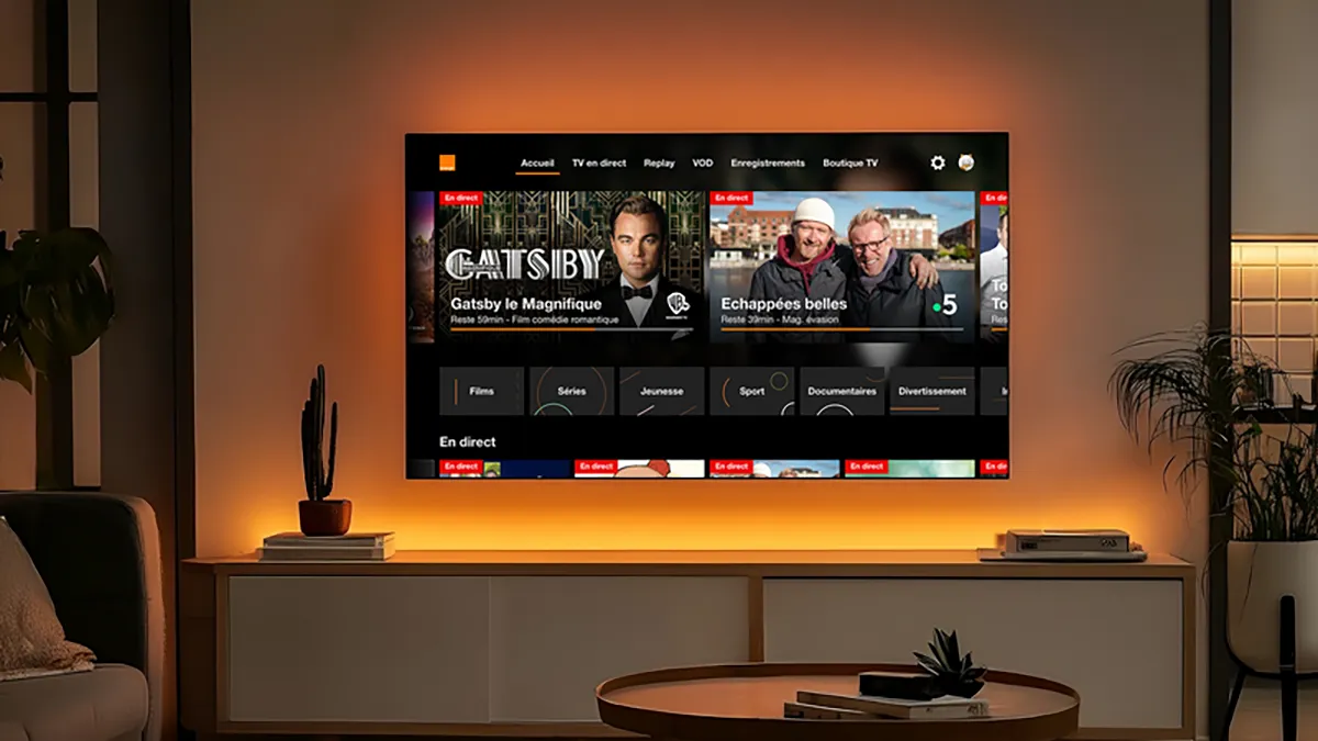 TV d’Orange sur téléviseur Philips Titan OS, écran d’accueil en direct et replay, halo Ambilight éclairant le mur du salon