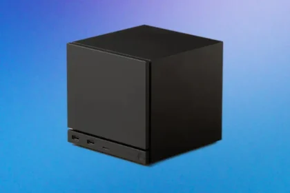 Mini-PC noir cubique rappelant une Steam Machine, posé sur fond bleu.